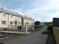 Level crossing and white rendered cottages